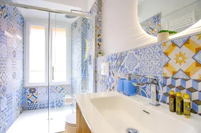 a bathroom with blue and white tiles and a sink at Elegantis Gracchi Apartment - Your Chic Retreat in Central Rome - Vatican Area in Rome