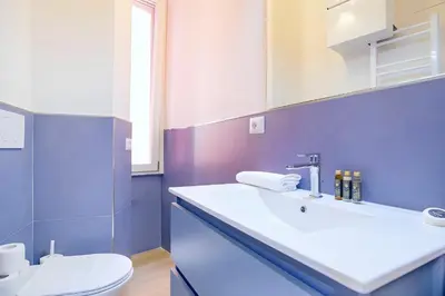a bathroom with a white sink and a toilet at Elegantis Veniero Suite Apartment - 1 Minute Walk to Vatican Museums in Rome
