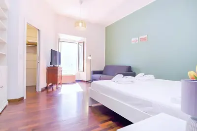 a bedroom with a bed and a couch and a tv at Elegantis Veniero Suite Apartment - 1 Minute Walk to Vatican Museums in Rome