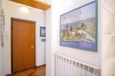 a hallway with a painting on the wall next to a door at Elegantis Veniero Suite Apartment - 1 Minute Walk to Vatican Museums in Rome