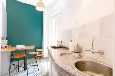 a bathroom with a sink and a blue wall at Elegantis Veniero Suite Apartment - 1 Minute Walk to Vatican Museums in Rome