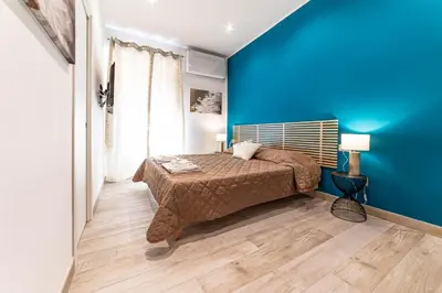 a blue bedroom with a bed and a blue wall at Michelangelo Luxury Rooms - Colosseo - WiFi in Rome