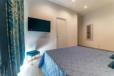 a bedroom with a bed and a flat screen tv at Michelangelo Luxury Rooms - Colosseo - WiFi in Rome