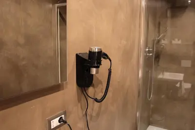a phone is plugged into a wall in a bathroom at I LOVE ROMA Guest House in Rome