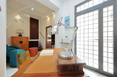 a desk with a lamp on a table in a room at Rifugio segreto nel cuore di Roma in Rome