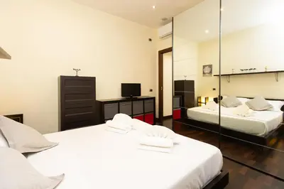 two beds in a room with a mirror at Nel Cuore di Testaccio by Rental in Rome in Rome