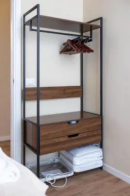 a bedroom closet with a black and wooden dresser at The Heartbeat of Bohemian Rome in Rome