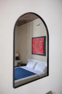 a mirror reflection of a bed in a bedroom at The Heartbeat of Bohemian Rome in Rome