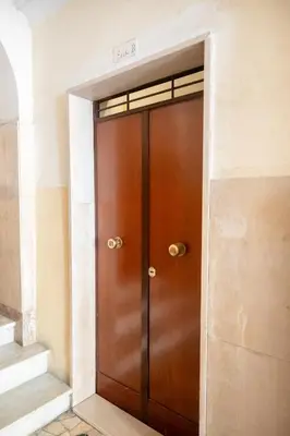 a wooden door in a room with stairs at Yellow Pop Apartment - Design e Colore a Roma in Rome