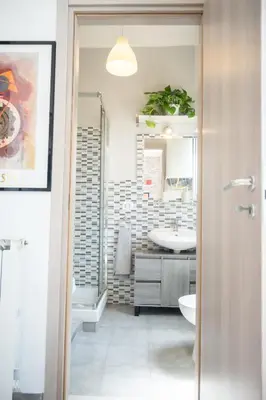 a bathroom with a sink and a toilet and a mirror at Yellow Pop Apartment - Design e Colore a Roma in Rome