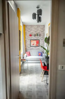 a hallway with a living room with a brick wall at Yellow Pop Apartment - Design e Colore a Roma in Rome