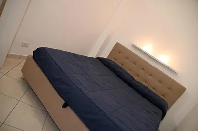a bed with a blue comforter in a room at Stefy's House Appio Tuscolano in Rome