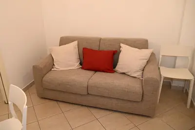 a brown couch with three pillows on it at Stefy's House Appio Tuscolano in Rome