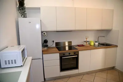 a kitchen with white cabinets and a white refrigerator at Stefy's House Appio Tuscolano in Rome