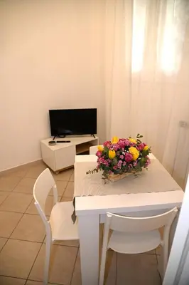 a white table with a bouquet of flowers on it at Stefy's House Appio Tuscolano in Rome