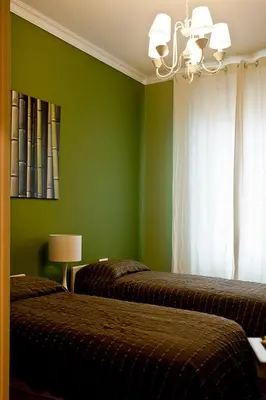 a bedroom with two beds and a green wall at St Peter Vatican wonderfull view apartment in Rome