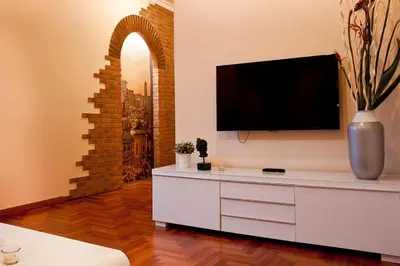 a living room with a white dresser with a flat screen tv at St Peter Vatican wonderfull view apartment in Rome