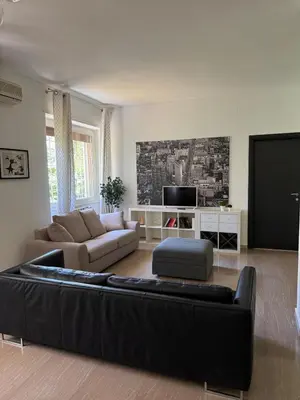 a living room with a black couch and a tv at Appia 101 Guest House in Rome