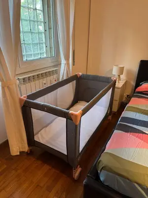 a baby crib in a bedroom with a window at Appia 101 Guest House in Rome