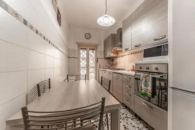a kitchen with a wooden table and chairs in it at Vacanze Romane - Metro Teano & Wi-Fi in Rome