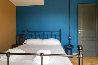 a bedroom with a blue wall and a bed at Livin' San Lorenzo in Rome