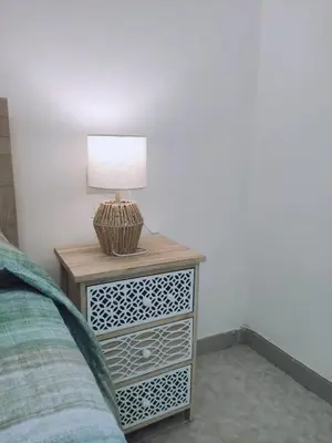 a nightstand with a lamp on it next to a bed at Rifugio del Quadraro Rome in Rome