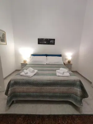 a bedroom with a large bed with two towels on it at Rifugio del Quadraro Rome in Rome