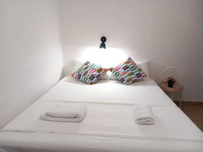 a bed with white sheets and pillows in a room at TravelR's Home in Rome