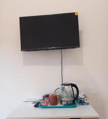 a monitor on top of a table with a coffee maker and a blender at TravelR's Home in Rome