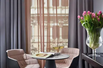 a table and chairs with a vase of flowers and a window at Leon's Place Hotel In Rome in Rome