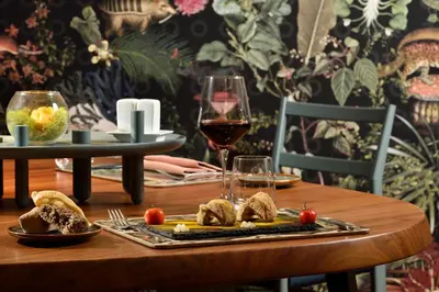 a table with a plate of food and a glass of wine at Leon's Place Hotel In Rome in Rome