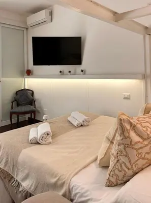 a bedroom with two beds and a flat screen tv at Casa Mari Vaticano in Rome