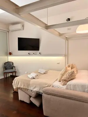 a bedroom with two beds and a flat screen tv at Casa Mari Vaticano in Rome
