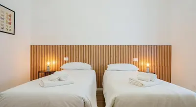 a white bedroom with a bed and a chair at Simi Roma Palombini, Appartamento con Giardino in Rome