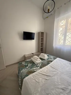 a white room with a bed and a television at Domus Battistini in Rome