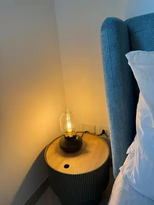 a small table with a candle on it next to a bed at Domus Battistini in Rome