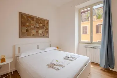 a bedroom with a white bed with towels on it at Dante Art Home in Rome