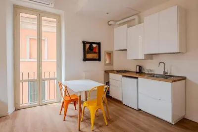 a kitchen with a table and chairs in a room at Dante Art Home in Rome