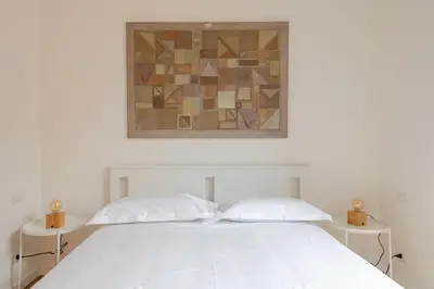 a bedroom with a white bed with two white pillows at Dante Art Home in Rome