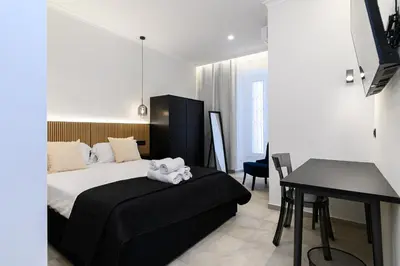 a bedroom with a bed and a table and a desk at Vittorio Emanuele Art Suites in Rome