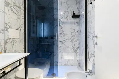 a bathroom with a glass shower with two toilets at Vittorio Emanuele Art Suites in Rome