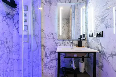 a purple bathroom with a sink and a shower at Vittorio Emanuele Art Suites in Rome
