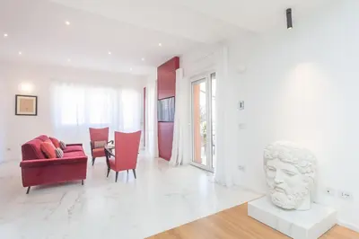 a white living room with a couch and a bust at Arte della Medaglia Gallery House in Rome