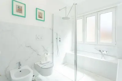 a white bathroom with a toilet and a tub and a sink at Arte della Medaglia Gallery House in Rome