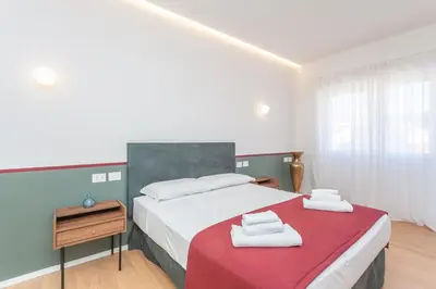 a bedroom with a large bed with a red blanket at Arte della Medaglia Gallery House in Rome