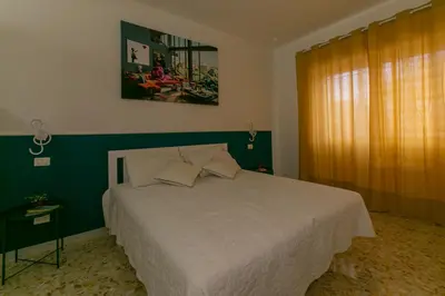 a bedroom with a white bed and a green wall at Casa Leone in Rome