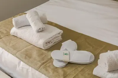 a bed with towels and a pair of shoes and towels at Vatican LeM collection in Rome