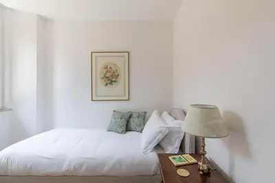 a bedroom with a white bed and a table with a lamp at iFlat Historic Charm & Comfort by Piazza Navona in Rome