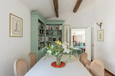 a dining room with a table with a vase of flowers at iFlat Historic Charm & Comfort by Piazza Navona in Rome