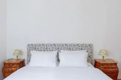 a bedroom with a white bed with two night stands at iFlat Historic Charm & Comfort by Piazza Navona in Rome